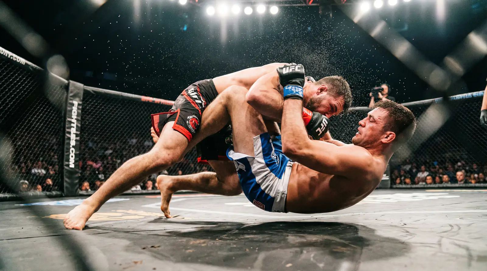 Primer plano de un derribo durante un combate de MMA en el octágono