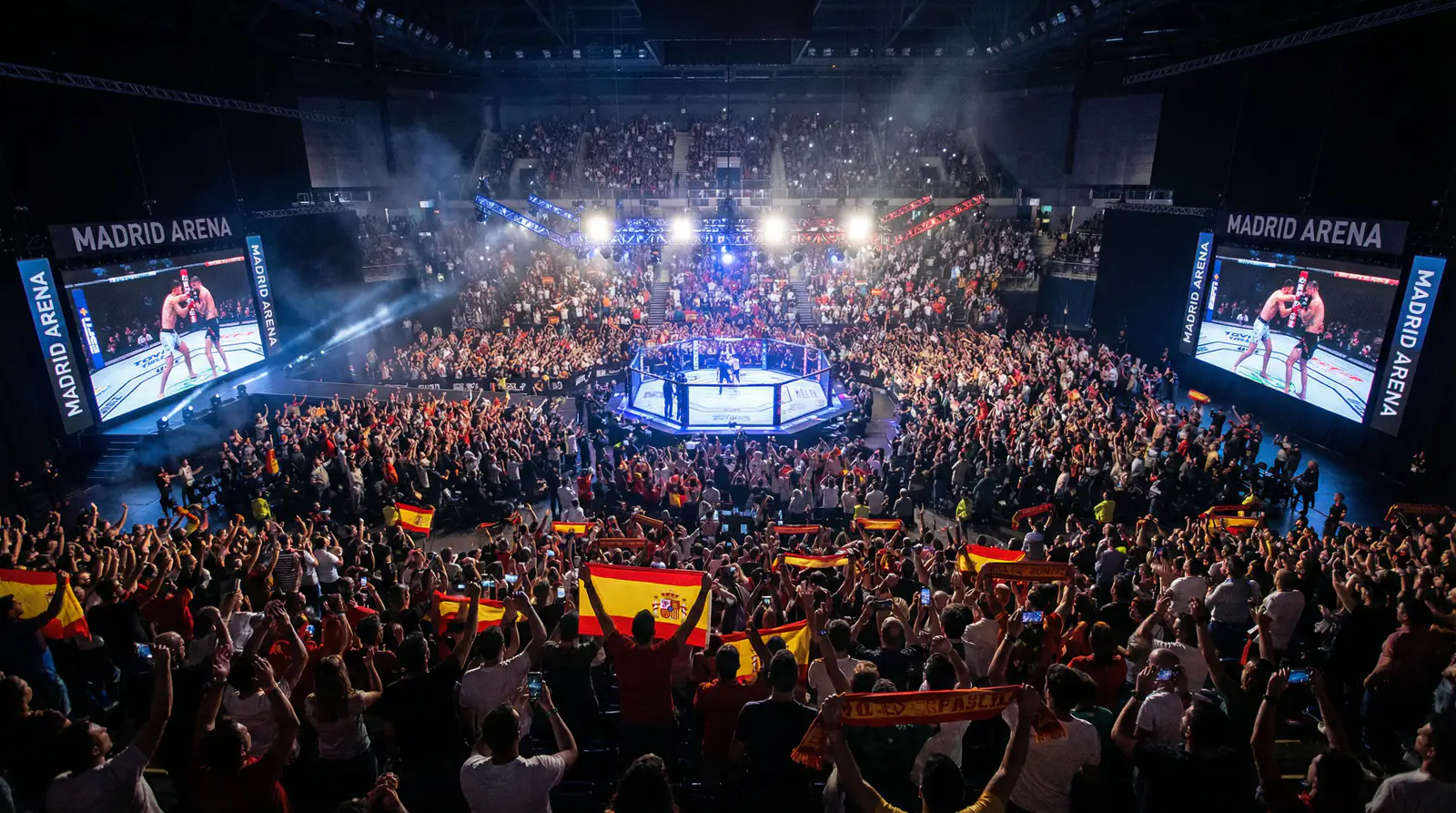 Ambiente de arena deportiva durante un evento de MMA con público entusiasmado